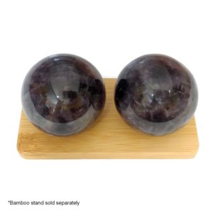 Amethyst baoding balls on a bamboo display stand