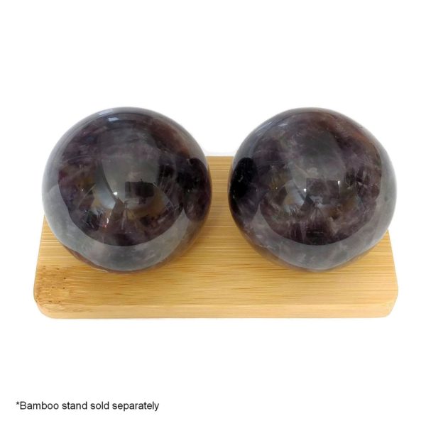 Amethyst baoding balls on a bamboo display stand