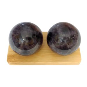 Amethyst baoding balls on a bamboo display stand