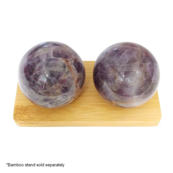 Amethyst baoding balls on a bamboo display stand