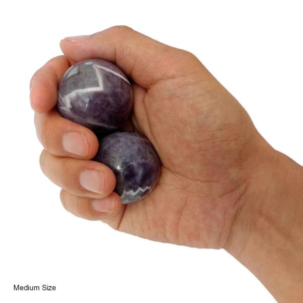 Hand holding medium amethyst baoding balls