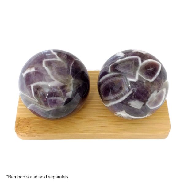 Amethyst baoding balls on a bamboo display stand