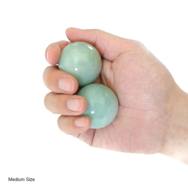 Hand holding medium aventurine baoding balls