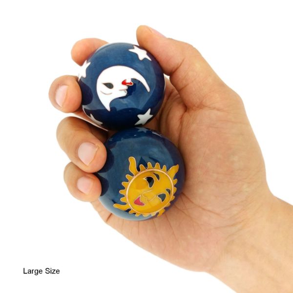 Hand holding large sun and moon baoding balls