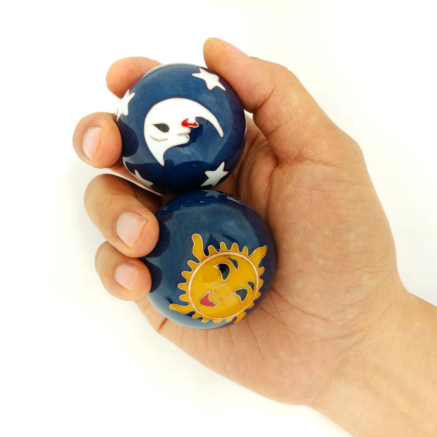 Hand holding large sun and moon baoding balls.