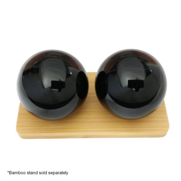 Black obsidian baoding balls on a bamboo display stand