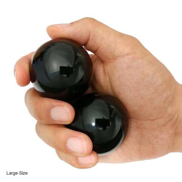 Hand holding black obsidian baoding balls