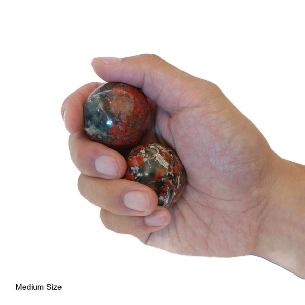 Hand holding brecciated jasper baoding balls