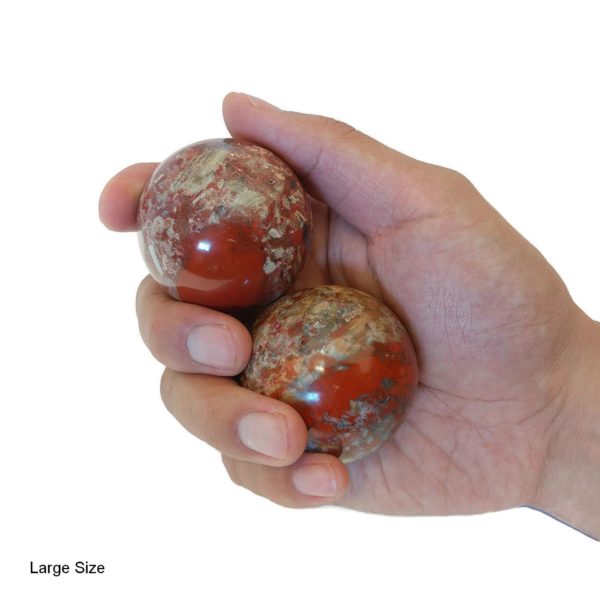 Hand holding brecciated jasper baoding balls