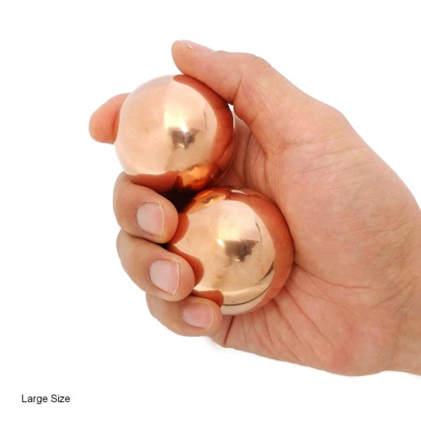 Hand holding large copper baoding balls