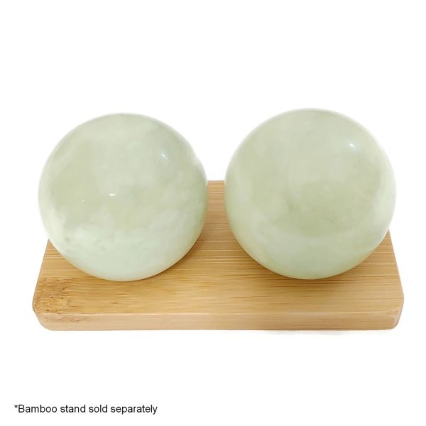 Green jade baoding balls on bamboo display stand