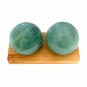 Green jade baoding balls on bamboo display stand