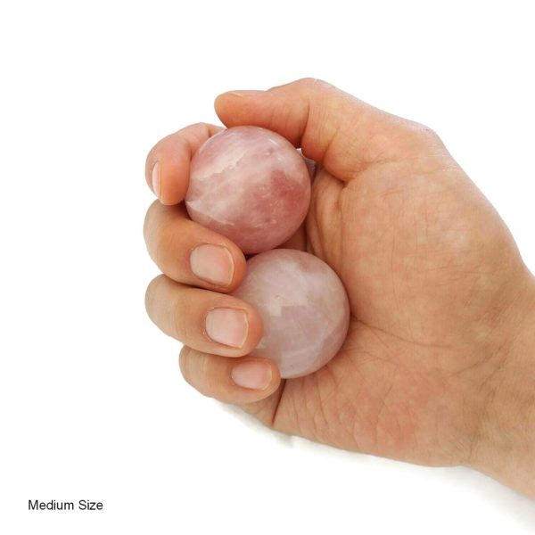 Hand holding medium rose quartz baoding balls