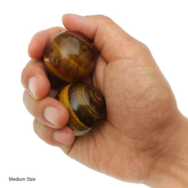 Hand holding tigers eye baoding balls