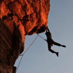 Man hanging on to cliff with his hands