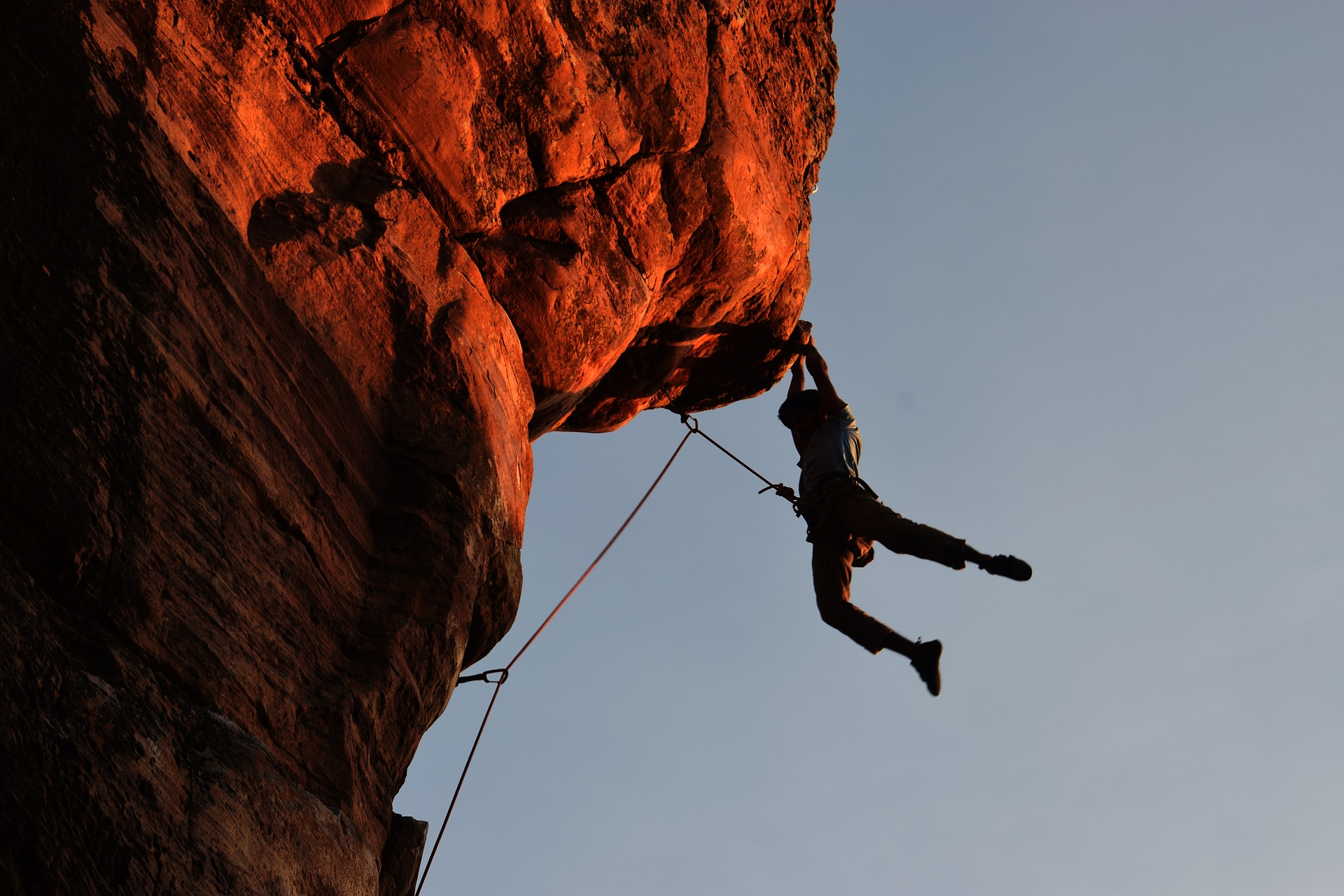 Man hanging on to cliff with his hands