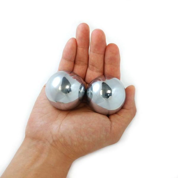 Hand holding large weighted chrome baoding balls