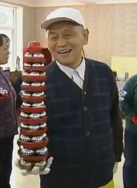 Li Zhanchun holding a baoding iron ball tower of 45 balls.