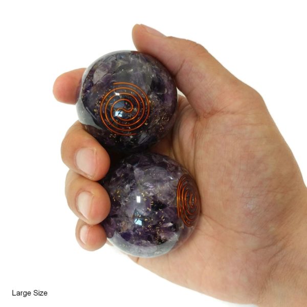Hand holding amethyst orgonite baoding balls
