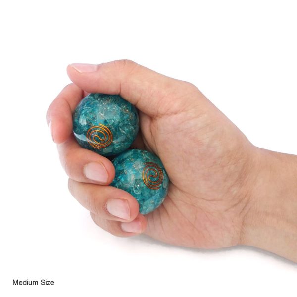 Hand holding aquamarine orgonite baoding balls