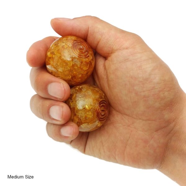 Hand holding medium citrine orgonite baoding balls