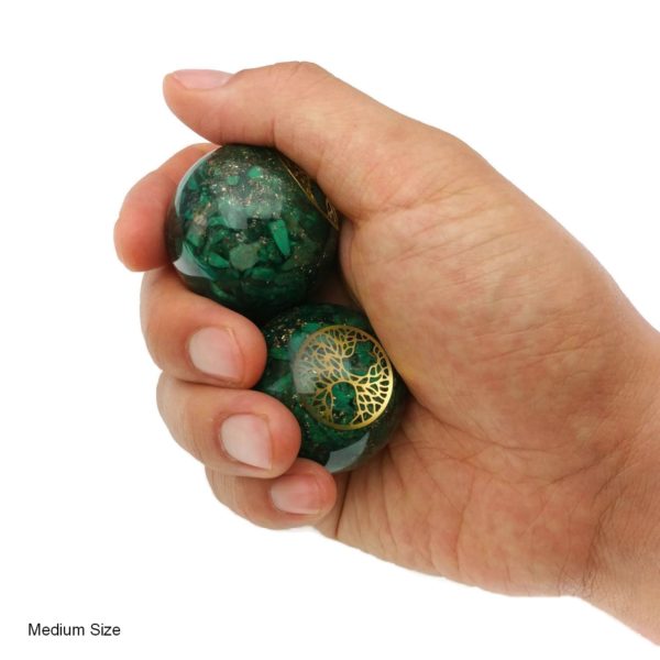 Hand holding malachite orgonite baoding balls with tree of life design