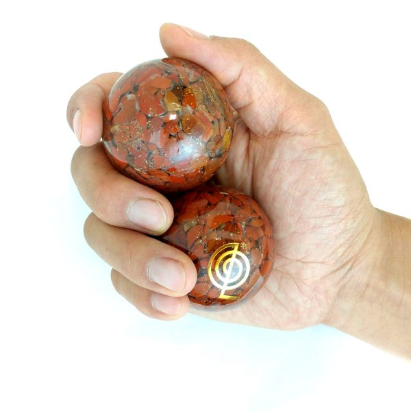 Hand holding 2 large red jasper orgonite baoding balls