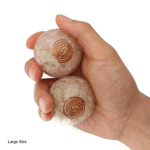 Hand holding rose quartz orgonite baoding balls