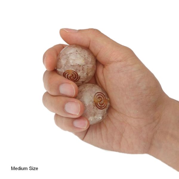 Hand holding rose quartz orgonite baoding balls