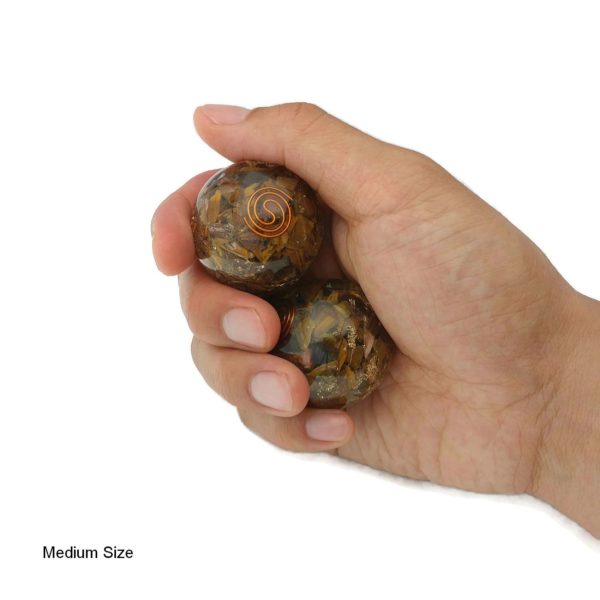 Hand holding tiger eye orgonite baoding balls