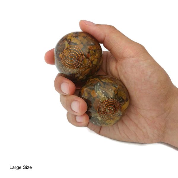 Hand holding tiger eye orgonite baoding balls
