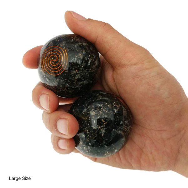 Hand holding large tourmaline baoding balls