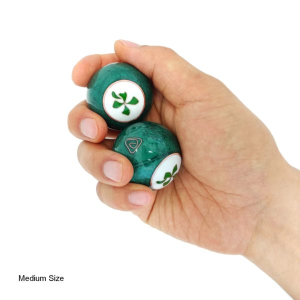 Hand holding medium four leaf clover baoding balls