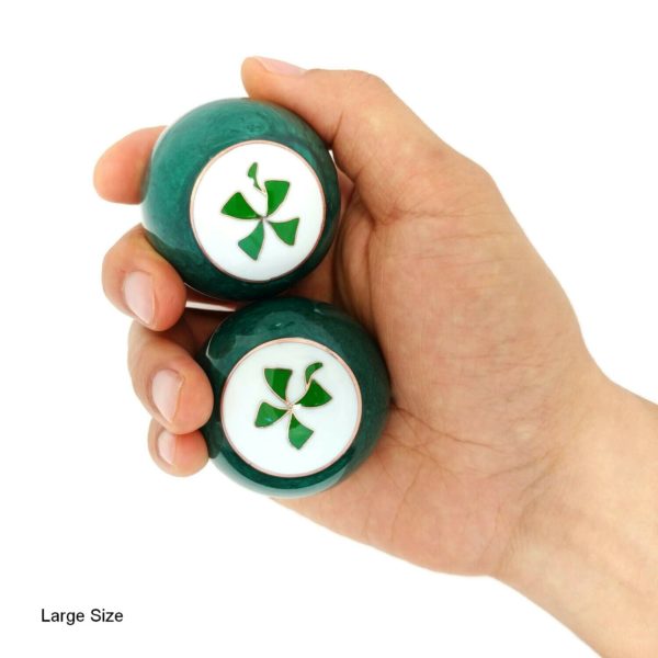 Hand holding large four leaf clover baoding balls