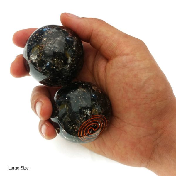 Hand holding black obsidian orgonite baoding balls