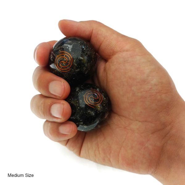 Hand holding black obsidian orgonite baoding balls