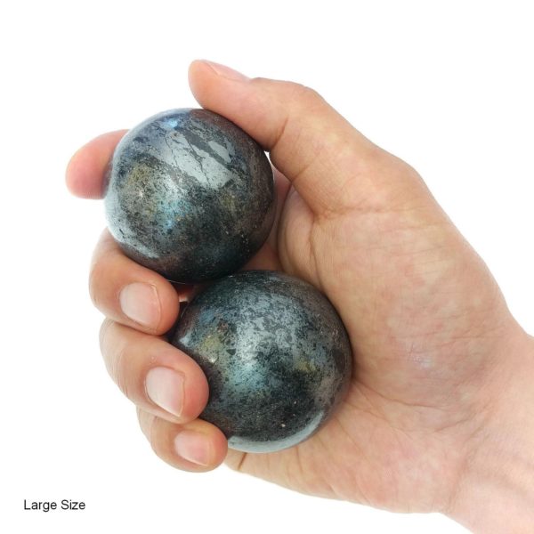 Hand holding large hematite baoding balls
