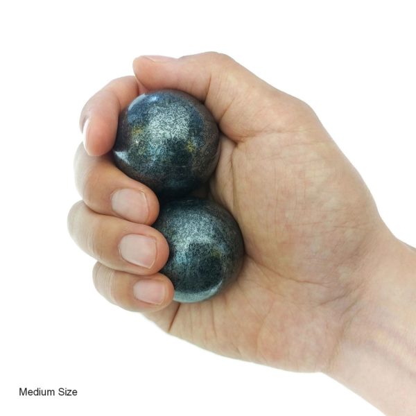 Hand holding medium hematite baoding balls