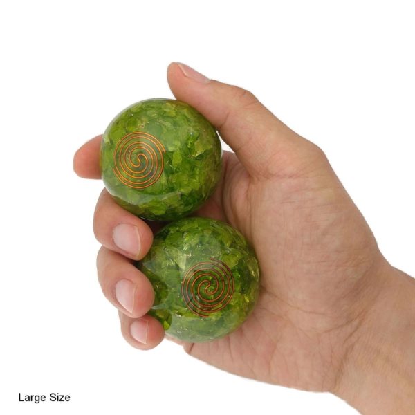 Hand holding peridot quartz baoding balls