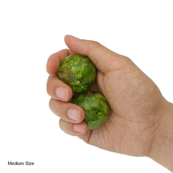 Hand holding peridot quartz baoding balls