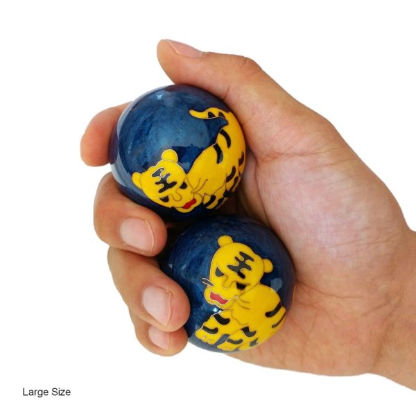 Hand holding large tiger baoding balls