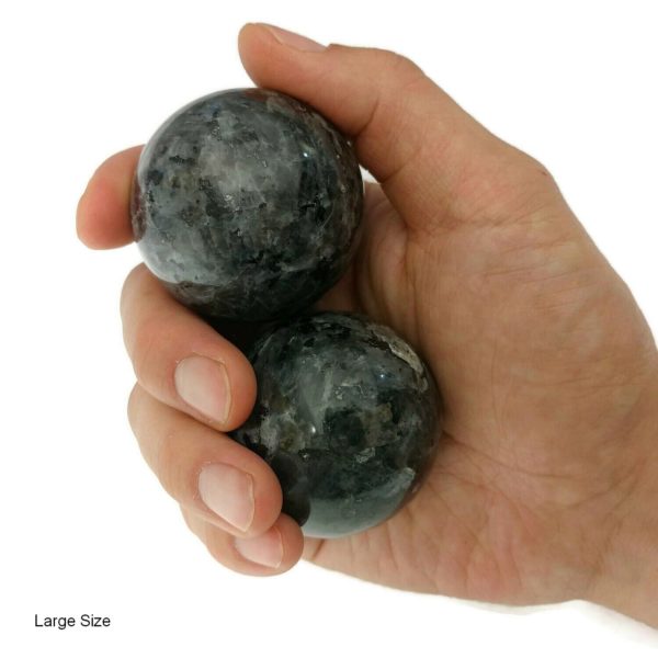 Hand holding large larvikite baoding balls