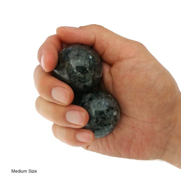 Hand holding medium larvikite baoding balls