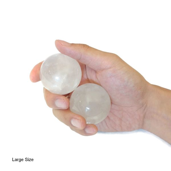 Hand holding clear quartz baoding balls