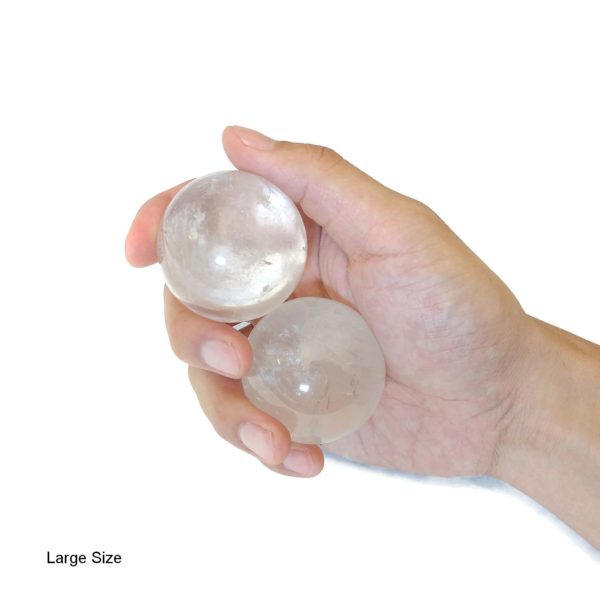 Hand holding clear quartz baoding balls