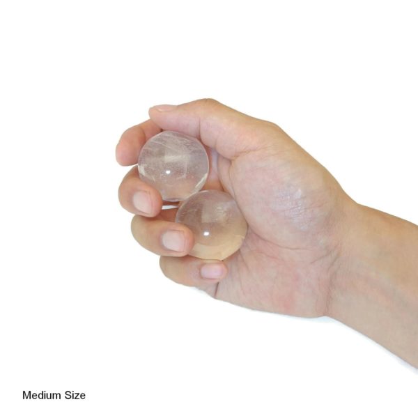 Hand holding clear quartz baoding balls