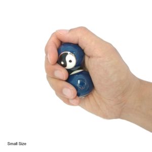 Hand holding small yin yang baoding balls